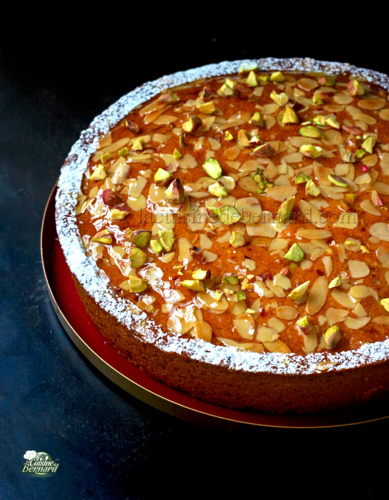 A cake with almonds and pistachios on a plate.