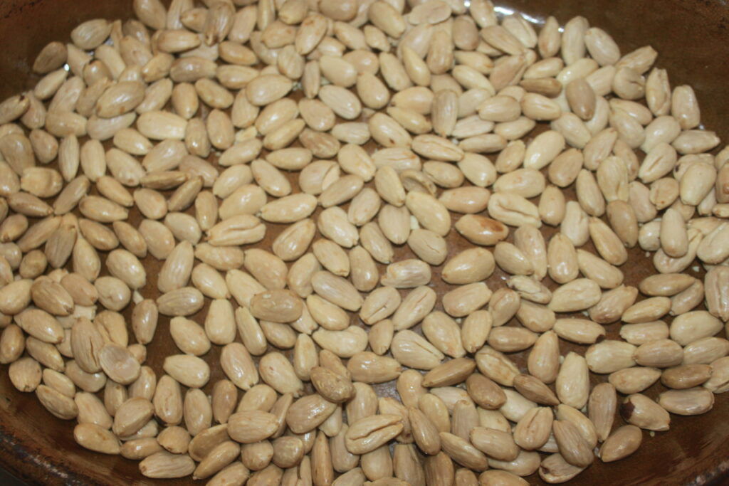 Gros plan d'amandes pelées et blanchies réparties uniformément, parfaites pour sublimer votre recette de sablés préférée.